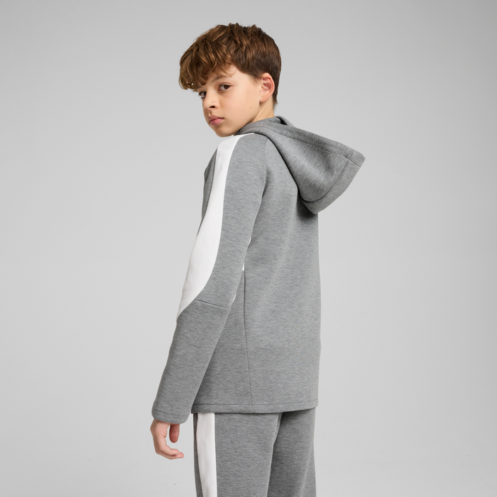 A child wearing a gray hooded jacket with white stripes and a hood, standing sideways.