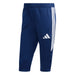 Navy blue Adidas pants with three white stripes on a light gray background