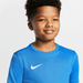 Close up of Boy Wearing Nike Dri FIT Park VII Short Sleeve Shirt in Royal Blue. White swoosh showing.
